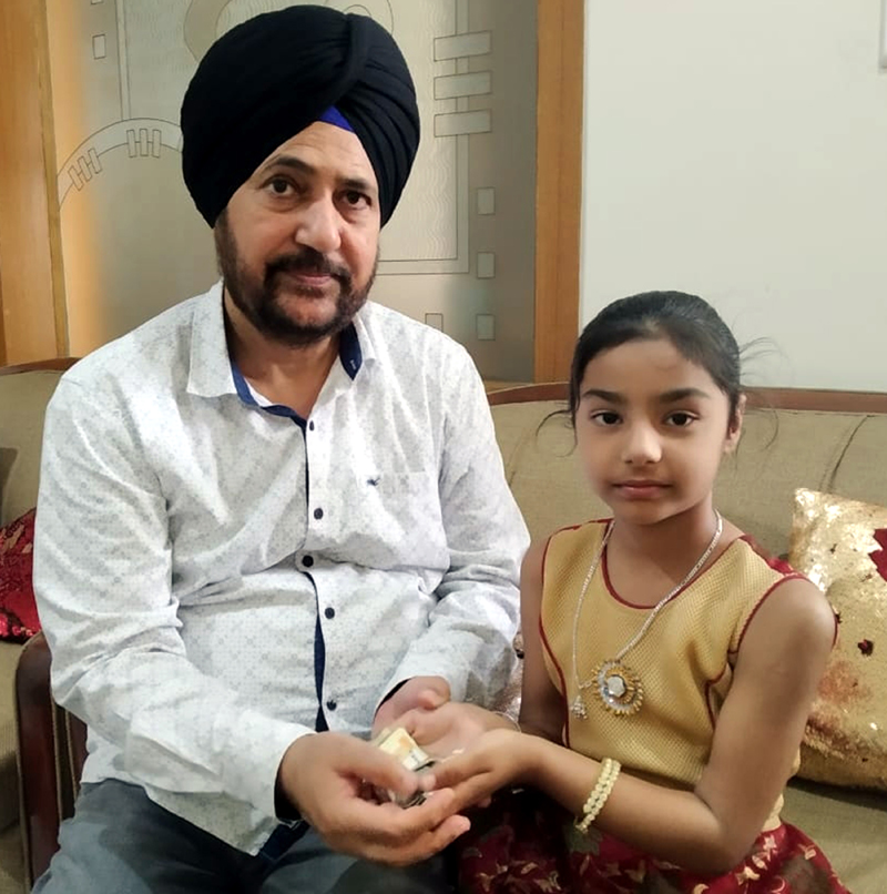 A girl child hands over her savings for PM CARES Fund to Dr Narinder Singh, vice-president, J&K BJP. A girl child hands over her savings for PM CARES Fund to Dr Narinder Singh, vice-president, J&K BJP.