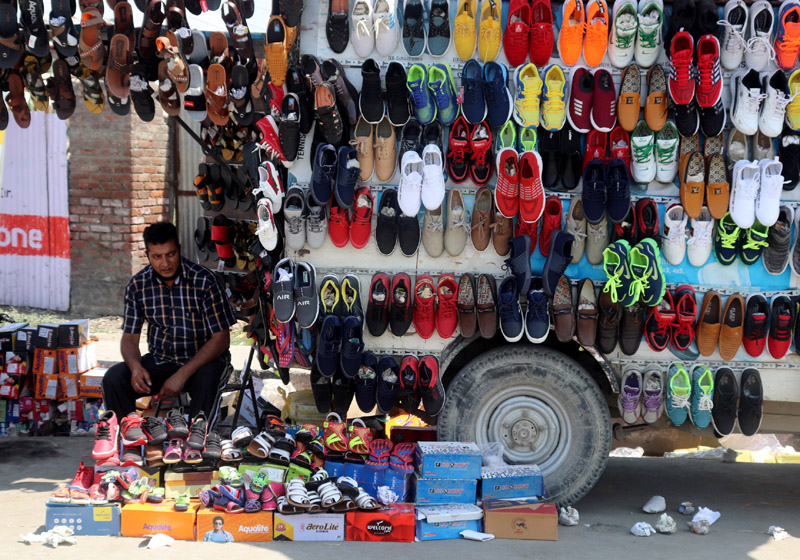 A shoe-seller waiting for customers on Eid-ul-Azha eve in Srinagar. -Excelsior/Shakeel A shoe-seller waiting for customers on Eid-ul-Azha eve in Srinagar. -Excelsior/Shakeel
