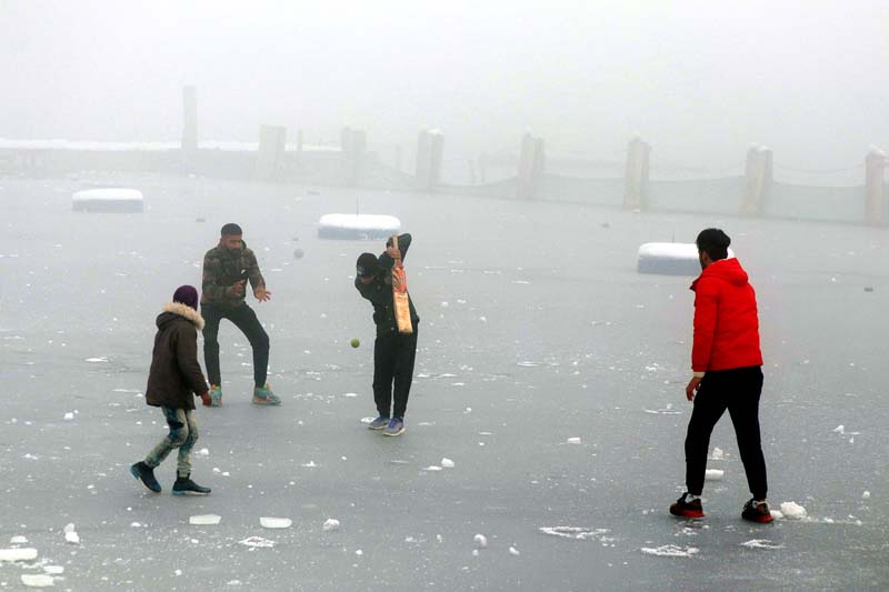 Boys playing cricket on frozen Dal lake in Srinagar on Thursday. -Excelsior/Shakeel Boys playing cricket on frozen Dal lake in Srinagar on Thursday. -Excelsior/Shakeel