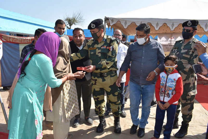 A senior BSF officer presenting hearing aid to an elderly woman during a medical camp at a border village in Jammu. A senior BSF officer presenting hearing aid to an elderly woman during a medical camp at a border village in Jammu.