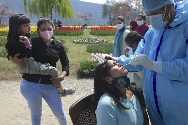 Health workers conducts COVID-19 tests of the tourists visiting Asia's largest tulip garden, in full bloom, along the banks of Dal Lake on the foothills of Zabarwan mountains, in Srinagar.
