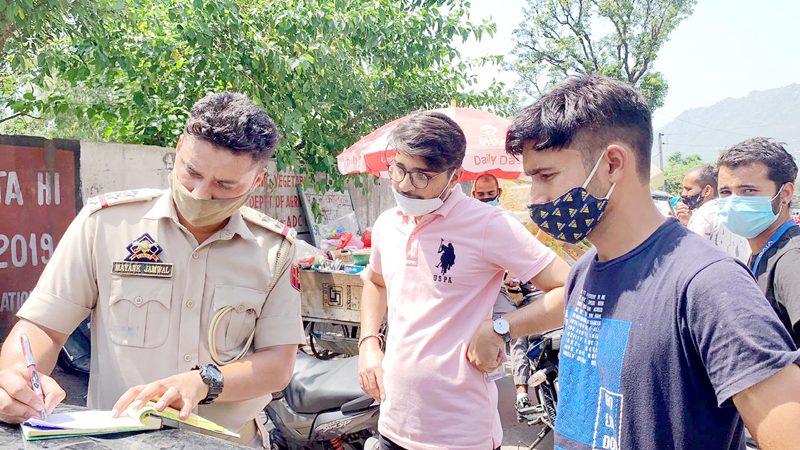 Cop challaning violators of Covid SOPs in Reasi on Tuesday. Cop challaning violators of Covid SOPs in Reasi on Tuesday.