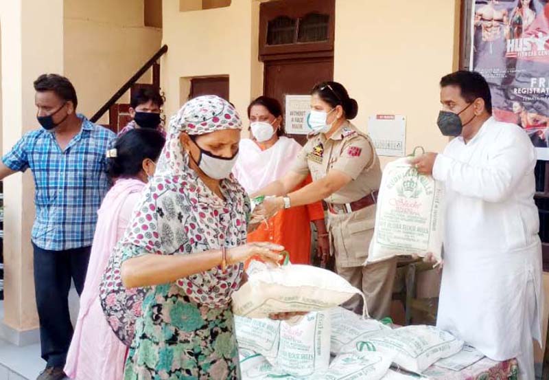 BJP leader Rajeev Charak alongwith SHO Bahu Fort distributing ration among needy families in Jammu. BJP leader Rajeev Charak alongwith SHO Bahu Fort distributing ration among needy families in Jammu.