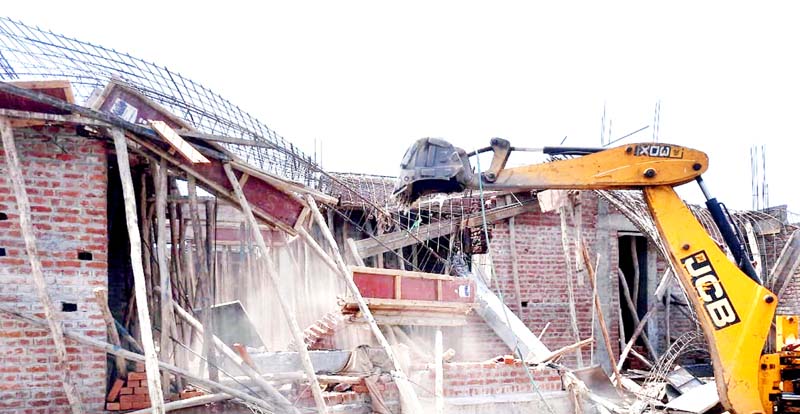 A JCB machine of JMC demolishing illegal structure at Sainik Colony, Jammu. A JCB machine of JMC demolishing illegal structure at Sainik Colony, Jammu.