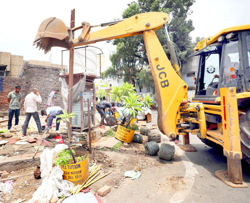 JMC removing encroachment from its land at Rehari Chungi on Friday. -Excelsior/Rakesh JMC removing encroachment from its land at Rehari Chungi on Friday. -Excelsior/Rakesh