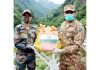 Indo-Pak Army officials exchange sweets along LoC in Kashmir on Wednesday.