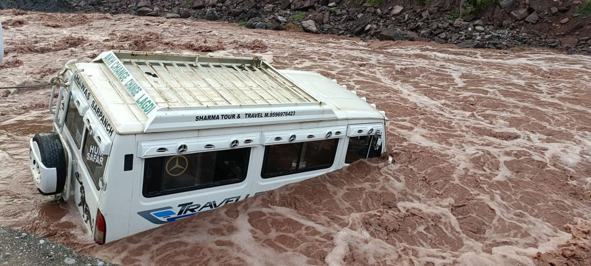 A Tempo Traveller trapped in flooded Patti Nallah, near Tredu village in remote Khawas area of Rajouri district on Wednesday. -Excelsior/Amit A Tempo Traveller trapped in flooded Patti Nallah, near Tredu village in remote Khawas area of Rajouri district on Wednesday. -Excelsior/Amit