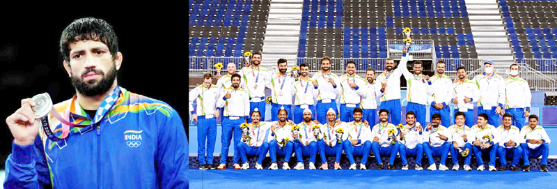 Ravi Dahiya shows silver medal while men’s hockey team pose for group photograph after winning bronze in Tokyo on Thursday. Ravi Dahiya shows silver medal while men’s hockey team pose for group photograph after winning bronze in Tokyo on Thursday.