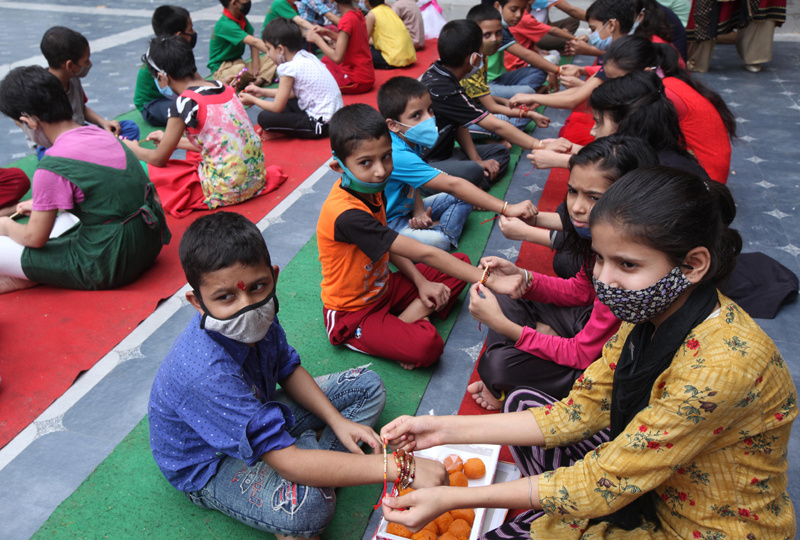 Girls tying Rakhis to inmate boys at Bal Ashram Ved Mandir, Jammu on Sunday. —Excelsior/Rakesh Girls tying Rakhis to inmate boys at Bal Ashram Ved Mandir, Jammu on Sunday. —Excelsior/Rakesh
