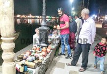 Tourists purchasing famous Kashmiri Paper Mache items from a vendor at Boulevard road on the banks of Dal lake in Srinagar. (UNI)