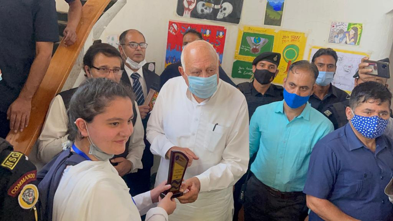 Dr Farooq Abdullah distributing prizes among winners of painting competition by People’s Help Group Initiative at Srinagar on Wednesday.