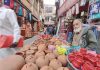 A vendor sells earthen lamps at a market ahead of Diwali festival at Rajouri town on Saturday. (UNI)