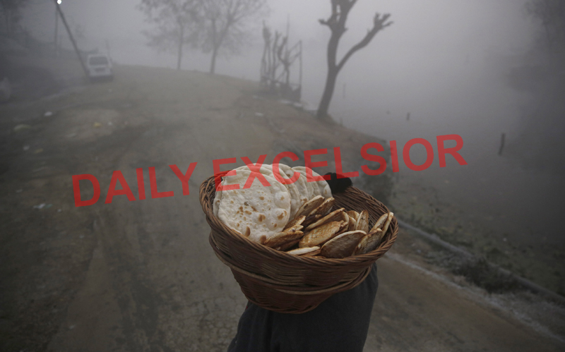 Amid fog, a man carries traditional bread early in the morning for further supply to people in Srinagar. —Excelsior/Shakeel