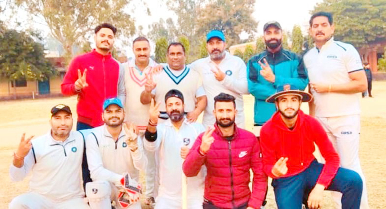 Players displaying victory signs while posing for group photograph at Akhnoor.