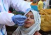A Health worker collects nasal swab sample of a woman for COVID-19 test in Jammu on Thursday. (UNI)