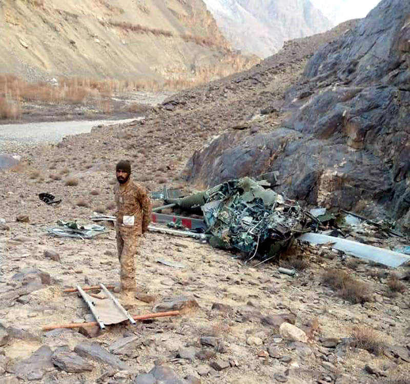 A jawan of Pak army stands near wreckage of crashed chopper in PoK. A jawan of Pak army stands near wreckage of crashed chopper in PoK.