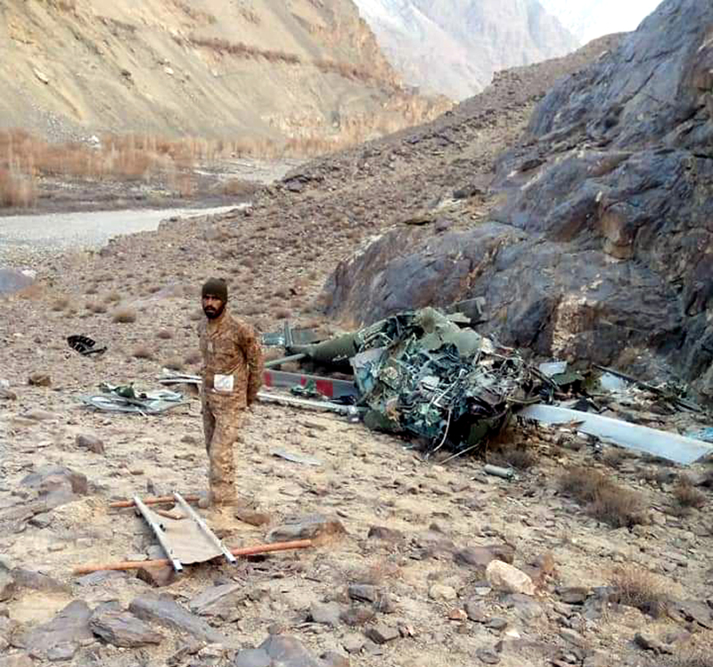 A jawan of Pak army stands near wreckage of crashed chopper in PoK.