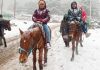 Tourists enjoying fresh snowfall at Pahalgam on Sunday. -Excelsior/Sajad Dar