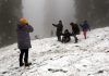 Tourists walk on snow covered Gulmarg on Sunday. -Excelsior/Aabid Nabi