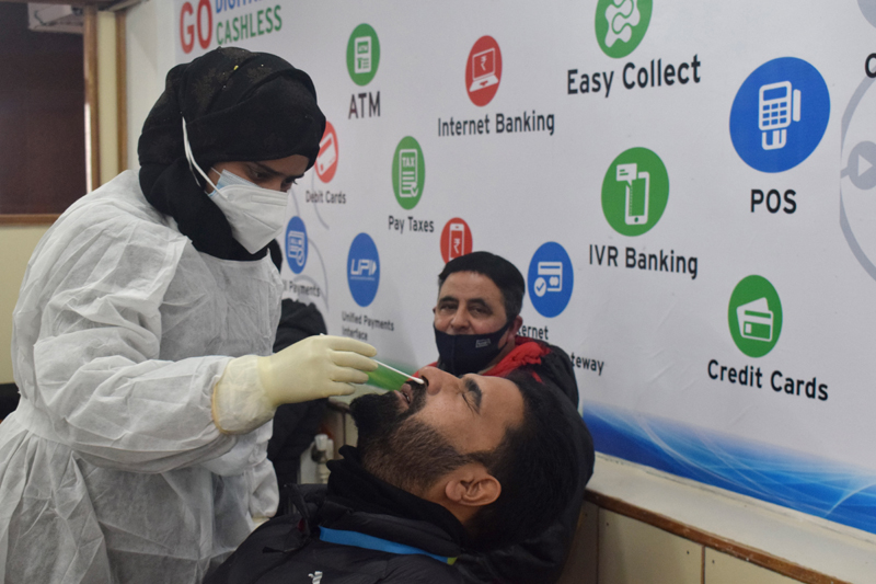 A Health worker takes a swab sample of JK Bank employee for Corona testing in Srinagar. —Excelsior/Shakeel