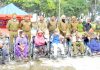 SSP Kathua, Romesh Chander Kotwal and other police officers posing for a photograph with specially abled persons at DPL Kathua after distributing wheel chairs among them on Wednesday.