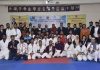 Dignitaries and players posing for a group photograph at Mahajan Hall Jammu during closing ceremony of Karate Championship.