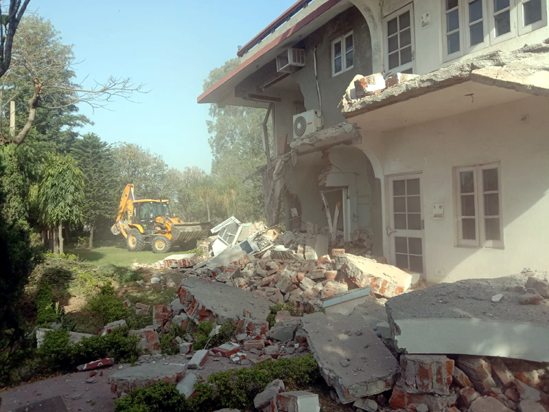 page3-3 Guest house of former minister and others being demolished during an anti encroachment drive in Jammu outskirts on Sunday. (UNI)