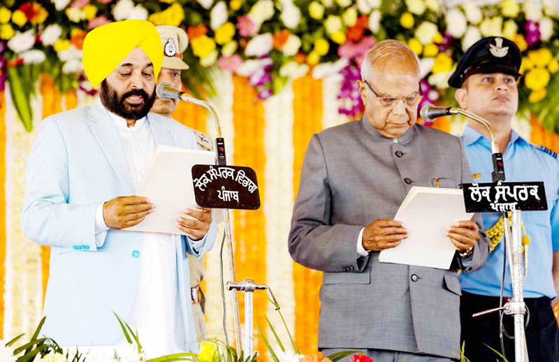 Punjab Governor Banwarilal Purohit administering oath to Bhagwant Mann as Chief Minister of Punjab during a swearing-in ceremony at Khatkar Kalan in Shaheed Bhagat Singh Nagar on Wednesday. (UNI) Punjab Governor Banwarilal Purohit administering oath to Bhagwant Mann as Chief Minister of Punjab during a swearing-in ceremony at Khatkar Kalan in Shaheed Bhagat Singh Nagar on Wednesday. (UNI)