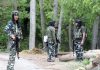 Army personnel walking towards the encounter site at Badigam Zainapora in Shopian on Thursday. (UNI)
