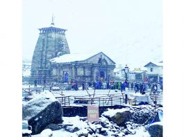 Pilgrims having darshan of Kedarnath shrine amid snowfall, in Kedarnath on Wednesday. (UNI)
