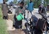 Residents cleaning blood stains on the road after militants fired upon a policeman in Srinagar on Saturday. (UNI)