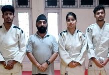 J&K Judokas posing for a group photograph with coach.