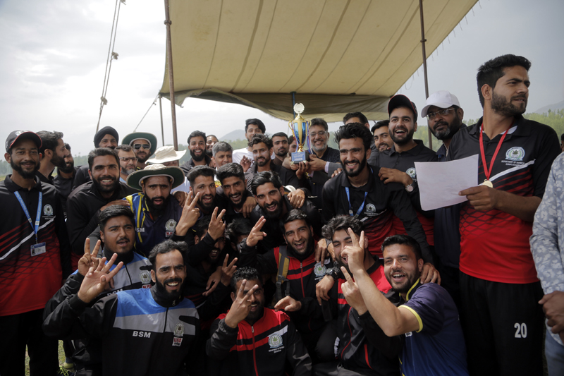 Winning team displaying winning signs after holding trophy at Central University of Kashmir on Thursday.