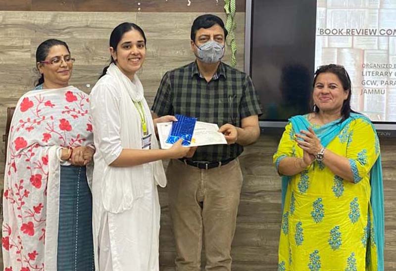 A student gets award for book review. A student gets award for book review.