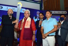 LG Manoj Sinha hands over the Chess Olympiad Torch to Chess Tournament Grandmaster Pravin Thipsay at SKICC in Srinagar on Tuesday.