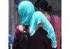 Woman with her child covered in scarf walking in a busy market on a hot summer day in Jammu on Sunday. — Excelsior/Rakesh