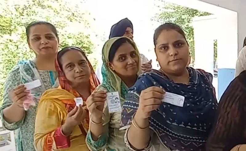 Sikh women displaying voter card while waiting for their turn to cast vote in DGPC elections on Monday.