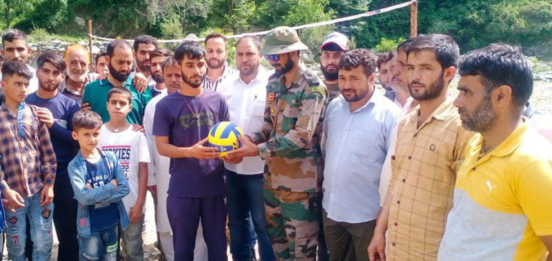 An Army officer handing over volleyball to a student in Surankote on Sunday.