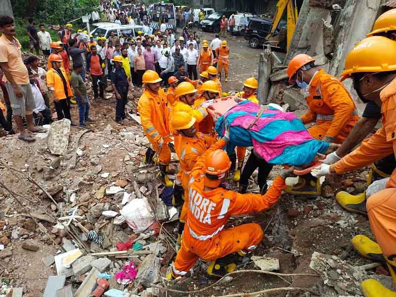 NDRF workers rescue a woman from the site of the four-storey building collapse, at Naik Nagar in Kurla East, Mumbai.