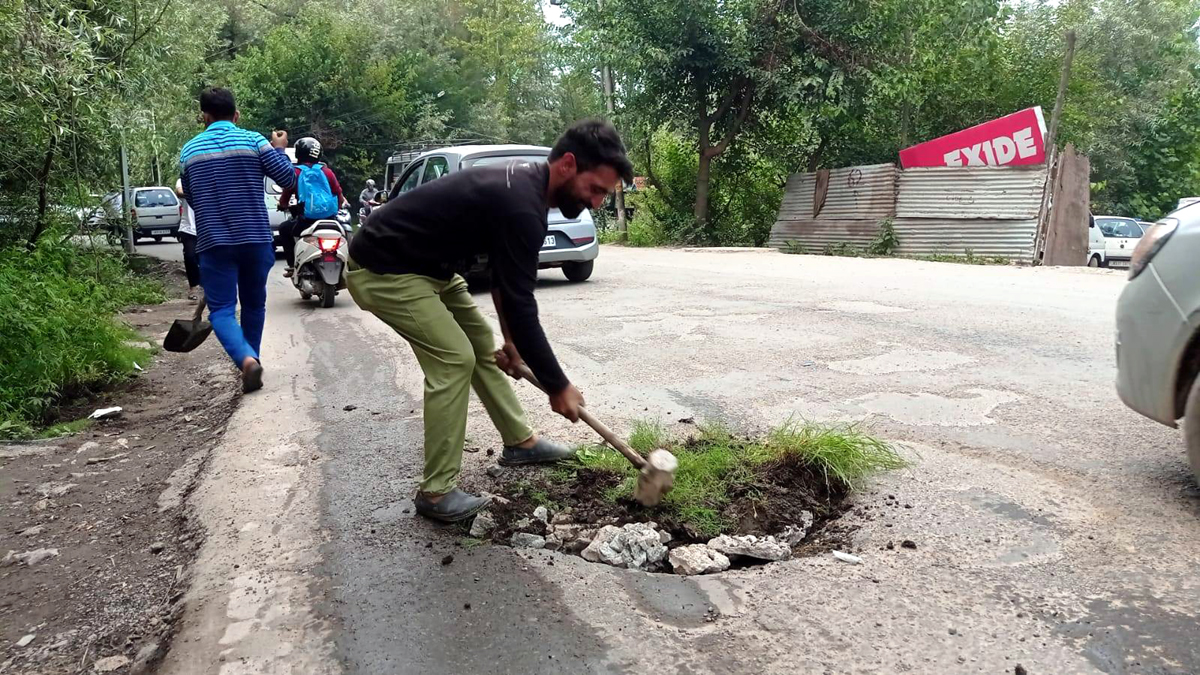 Residents filling road potholes. Residents filling road potholes.