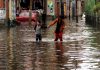 People walking on a waterlogged road in Srinagar after heavy rains on Thursday. (UNI)