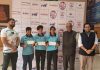 Footballers displaying cash prizes while posing with dignitaries at Jammu on Friday.