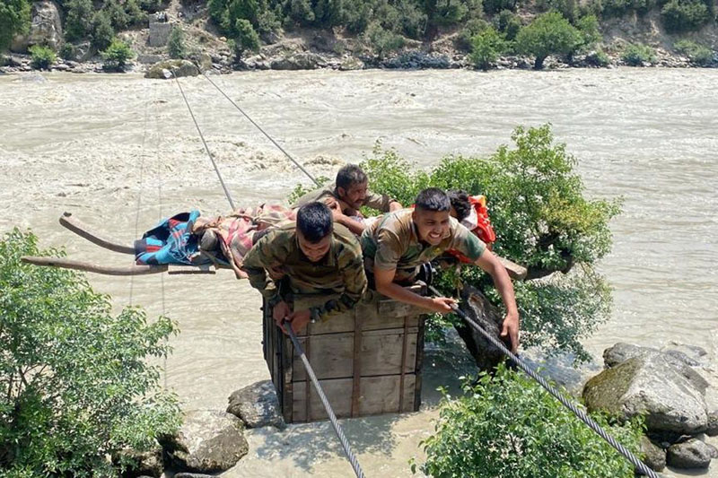 Army personnel evacuating injured youth.