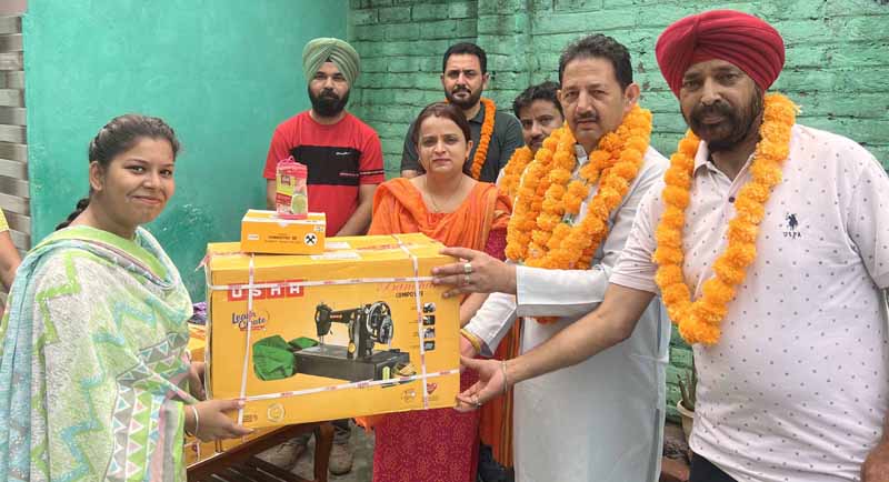 BJP senior leader Baldev Singh Billawaria handing over a sewing machine and tailoring kit to a beneficiary.