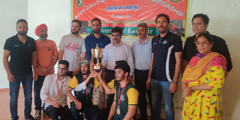 Registrar Dr Nisar and others presenting trophy to students at Kashmir University on Friday.