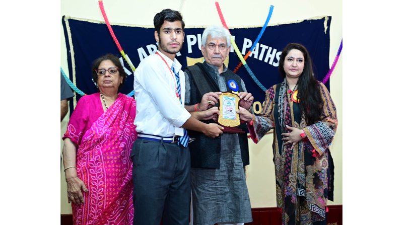 Lt Governor Manoj Sinha awarding a student during annual day celebration of Devki Arya Putri Pathshala, Srinagar on Friday.