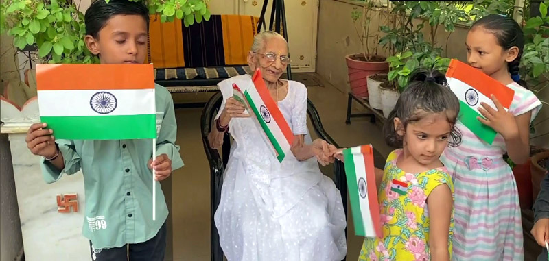 Heeraben Modi, mother of Prime Minister Narendra Modi distributes national flag to children and hoists the tricolour as the Har Ghar Tiranga campaign begins today.