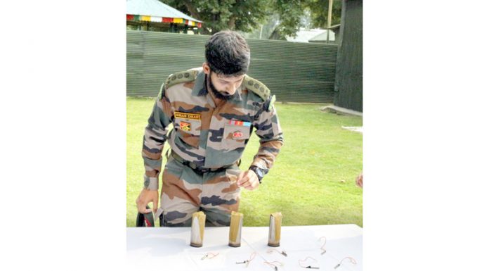 An officer displays sticky bombs recovered in Sopore on Sunday. — Excelsior/Aabid Nabi