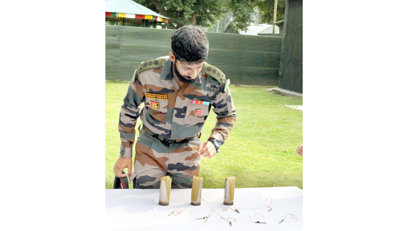 An officer displays sticky bombs recovered in Sopore on Sunday. — Excelsior/Aabid Nabi An officer displays sticky bombs recovered in Sopore on Sunday. — Excelsior/Aabid Nabi