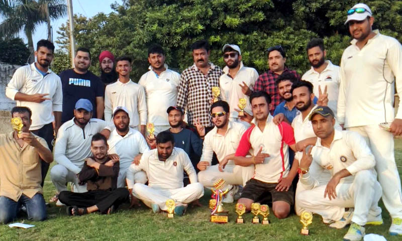 Winning team posing for a group photograph with trophies and match officials at KC Ground Jammu on Tuesday.